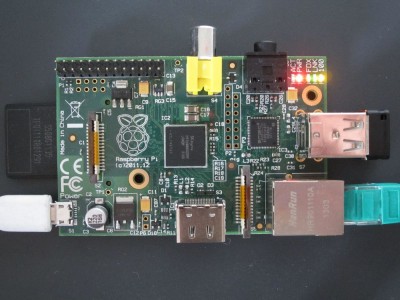 Der Raspberry Pi. Auf der rechten Seite ein USB Stick als Speichererweiterung und der Netzwerkanschluss. Links die SD Karte mit dem Betriebssystem und der Stromversorgung - einem Handynetzteil.